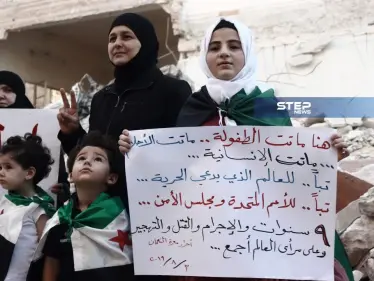 وقفة لنشطاء مدينة معرة النعمان جنوبي إدلب من مكان المجزرة التي ارتكبتها المُقاتلات الروسيّة - وكالة ستيب نيوز