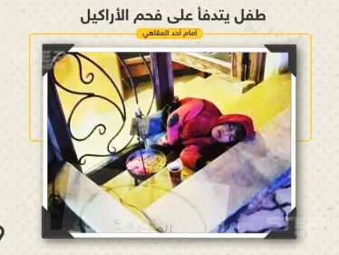 طفل يتدفأ على فحم الأراكيل أمام أحد المقاهي في مدينة اللاذقية - وكالة ستيب نيوز