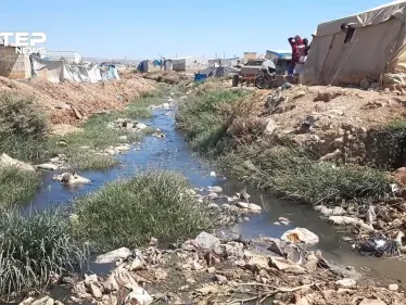 إضافة إلى ألم النزوح .. خيامهم على ضفاف قناة الصرف الصحي في أطمة بريف إدلب - وكالة ستيب نيوز