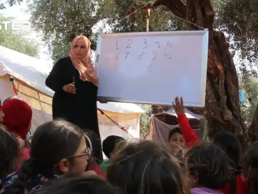تحت أشجار الزيتون تواصل المعلمة وئام تعليم الأطفال النازحين إلى مخيمات الشمال السوري - وكالة ستيب نيوز