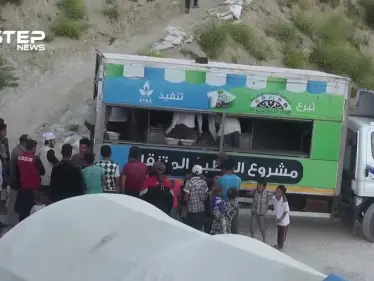 المطبخ المتنقل لمنظمة عطاء الخيرية يقوم بتوزيع وجبات إفطار صائم للنازحين في مخيمات ريف جسر الشغور الغربي - وكالة ستيب نيوز