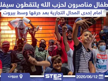 أطفال مناصرون لميليشيا حزب الله يلتقطون سيلفي أمام إحدى المحال التجارية بعد حرقها وسط بيروت - وكالة ستيب نيوز