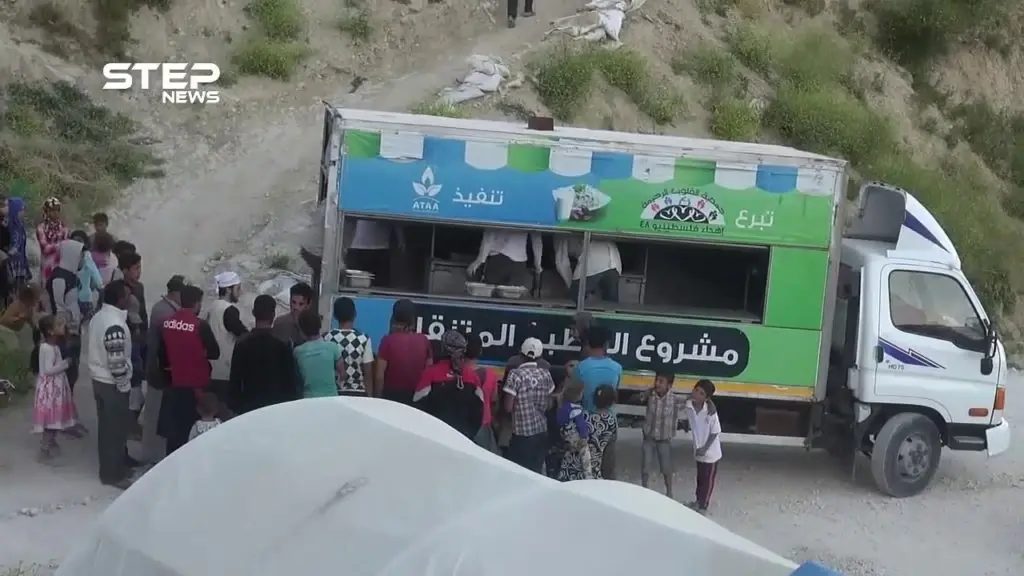 المطبخ المتنقل لمنظمة عطاء الخيرية يقوم بتوزيع وجبات إفطار صائم للنازحين في مخيمات ريف جسر الشغور الغربي: جسر الشغور